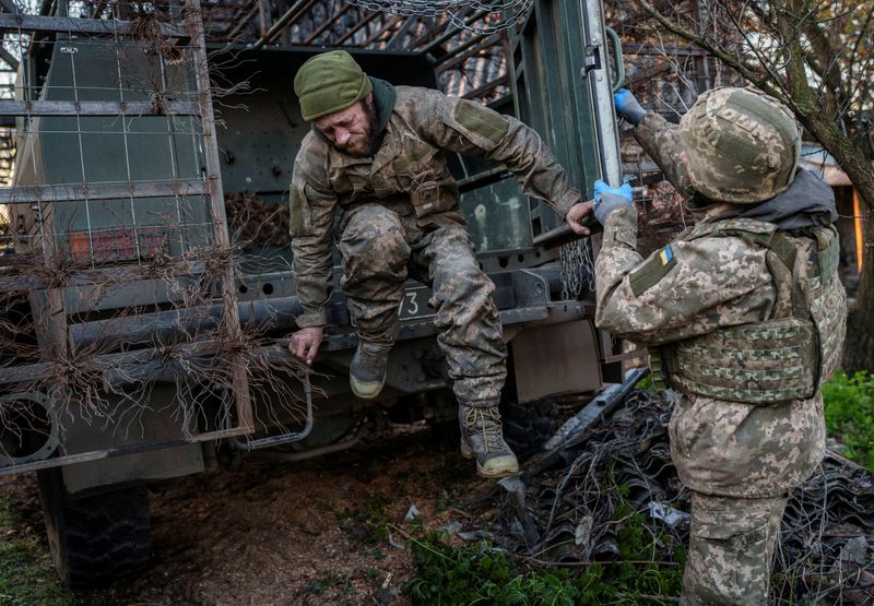 FILE PHOTO: Ukrainian servicemen return from a frontline position after manning it for about half a year, in Donetsk region
