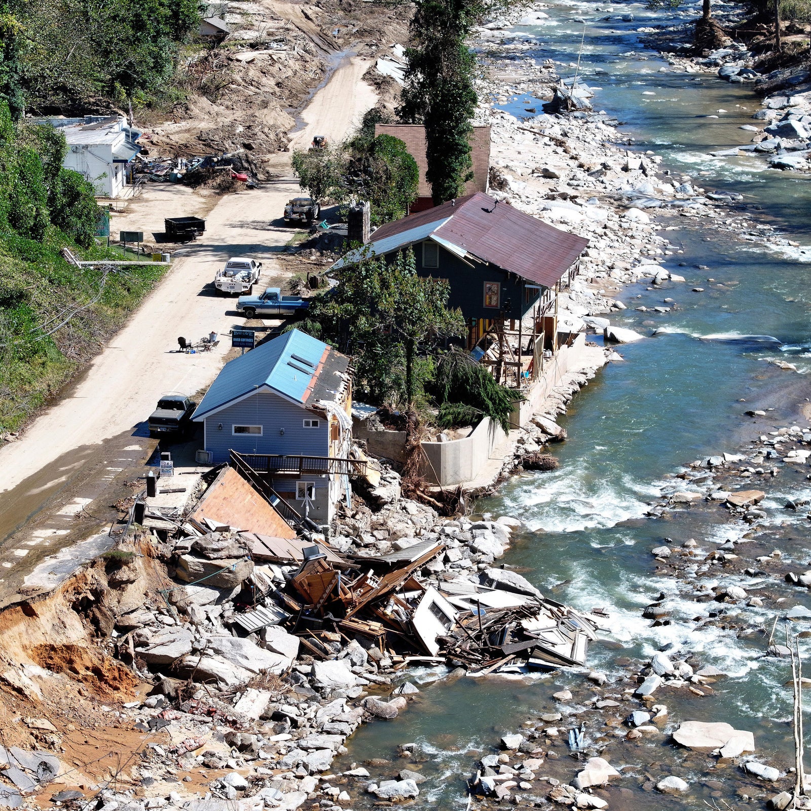 An aerial view of people standing near destroyed and damaged buildings in the aftermath of Hurricane Helene flooding on Oct. 8, 2024 in Bat Cave, North Carolina. B