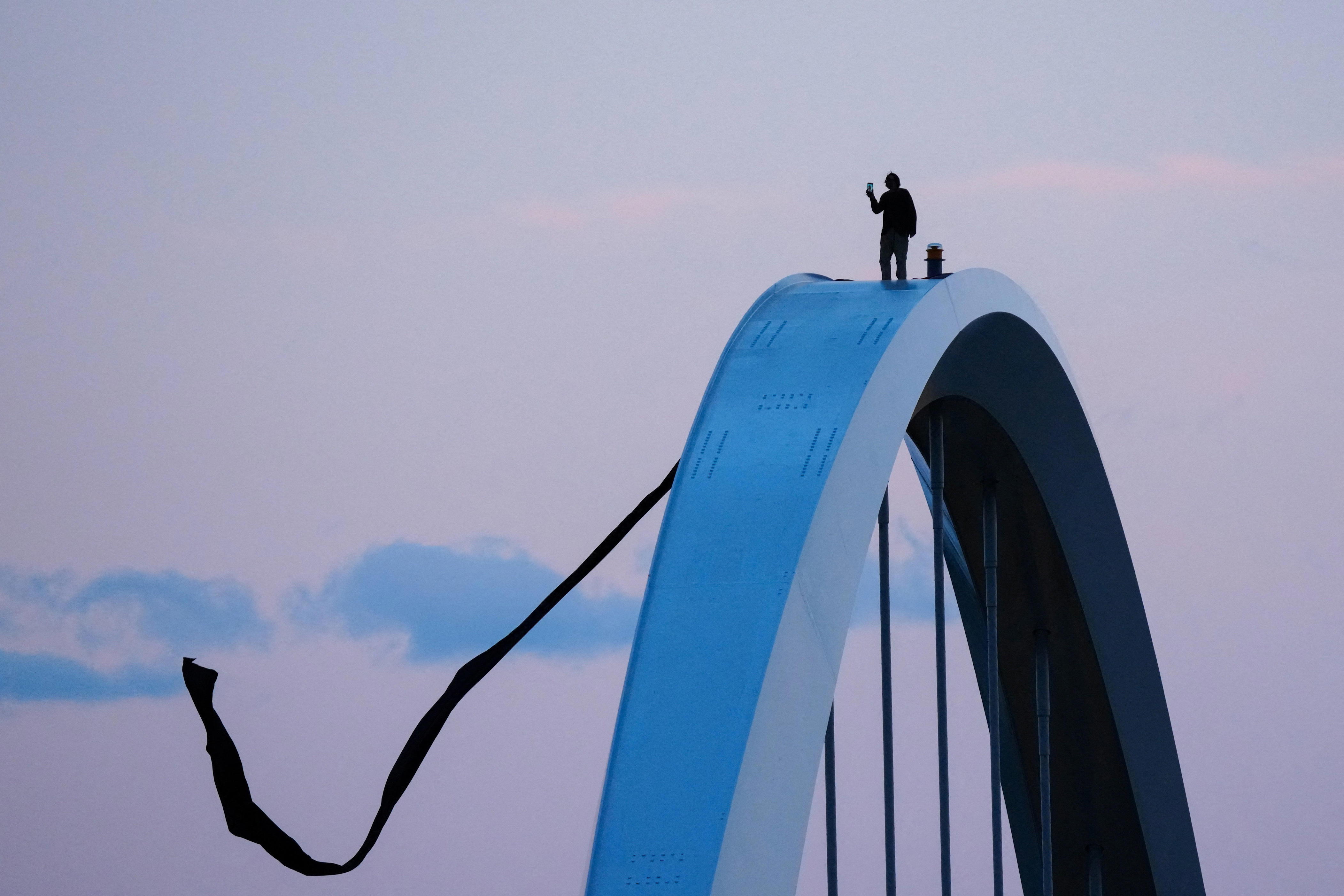 Stunning photos of the protester on top of a bridge in Washington, DC
