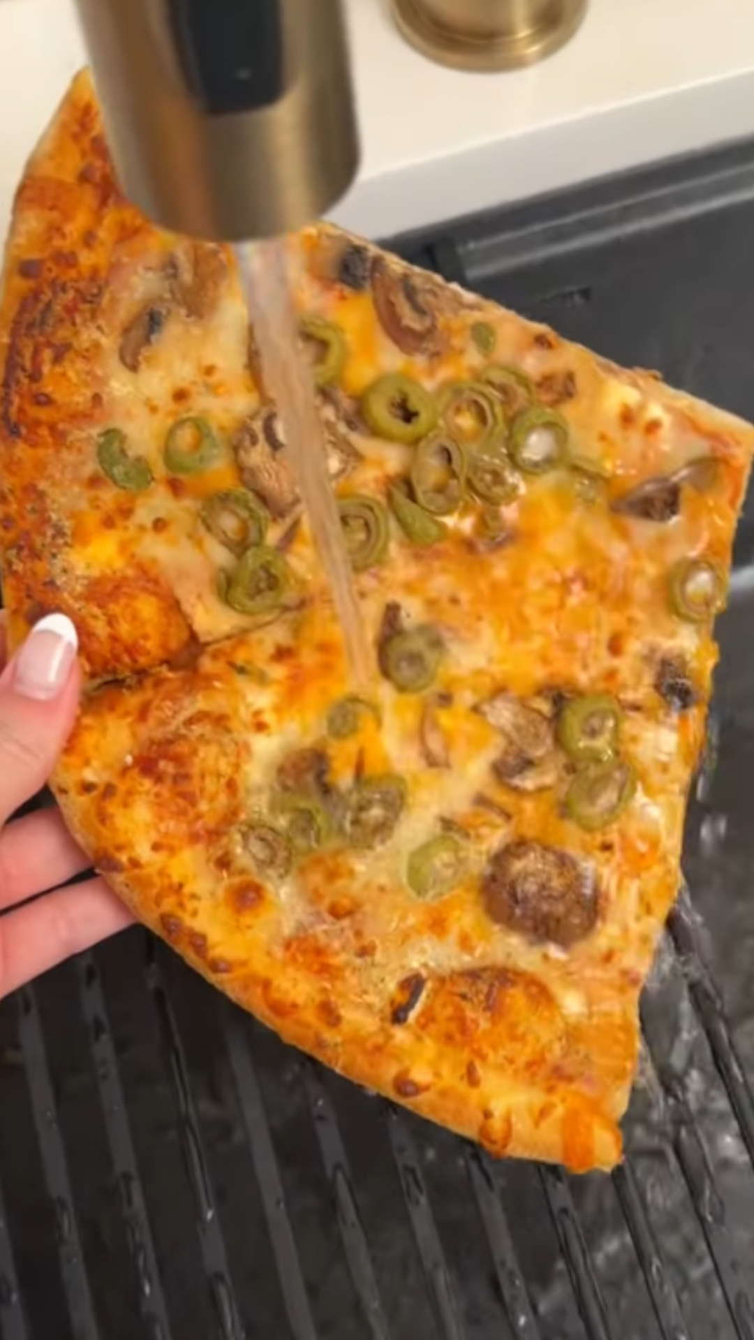 He puts pizza under the faucet, what happens next?
