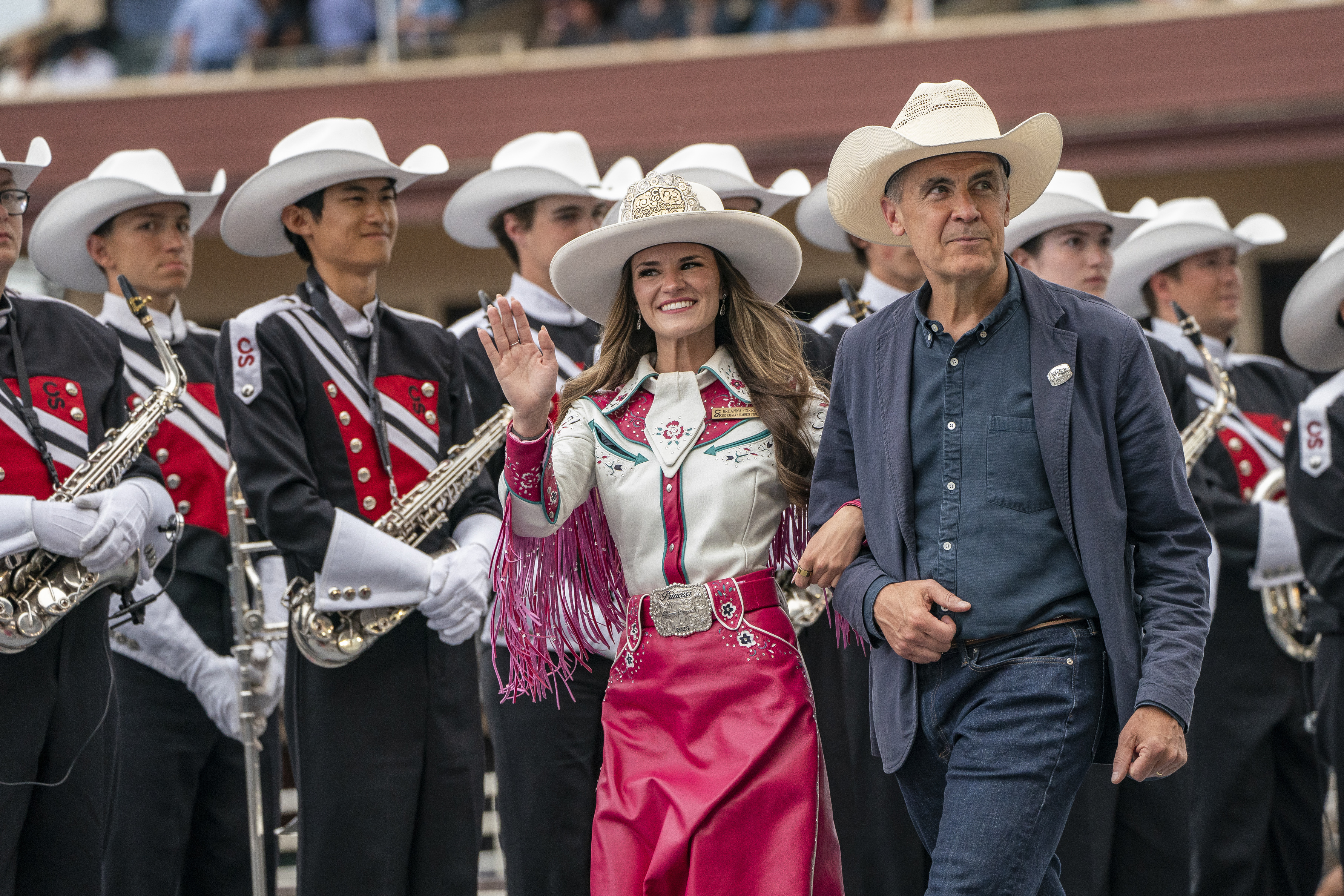 Calgary Princess Breanna Correia, left, walks with Canadian Prime Minister Mark Carney at the chuck wagon races during the Calgary Stampede on Friday, July 4, 2025, in Calgary, Alberta. (Photo by Amy Harris/Invision/AP)