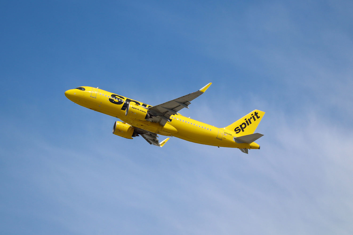 Spirit Airlines yellow aircraft soaring.