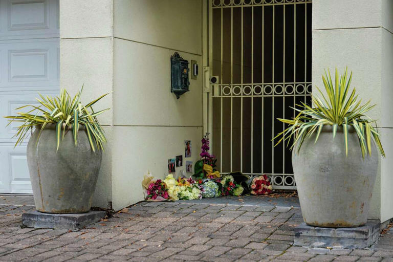 Photos and bouquets are seen in front of a River Oaks home where police found a family of four dead with gunshot wounds in Houston, Tuesday, May 5, 2026. (Raquel Natalicchio/Houston Chronicle)