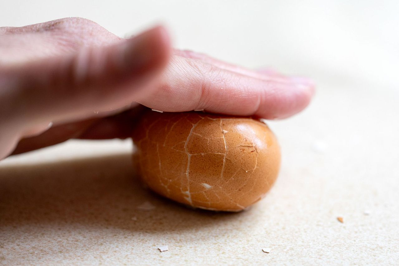 Peeling eggs by rolling them on a counter.