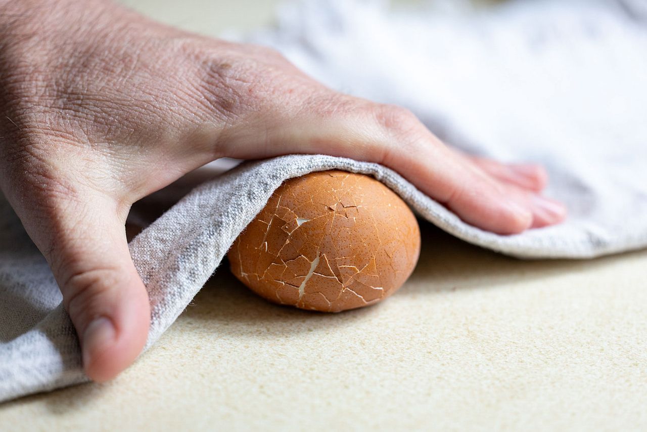 Peeling eggs by rolling with a towel.
