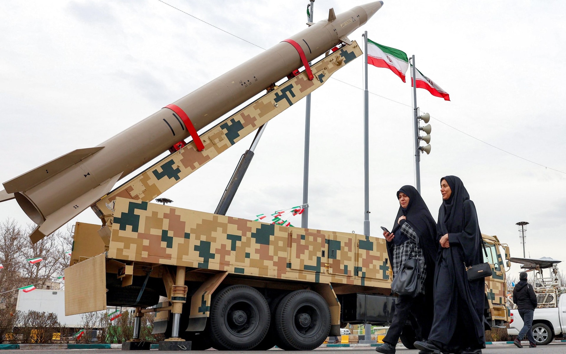 Women walking past a ballistic missile in Tehran