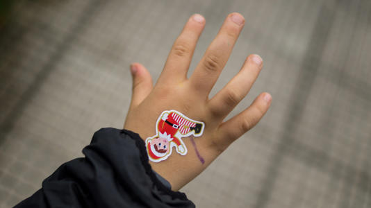 Child's hand with elf sticker on top