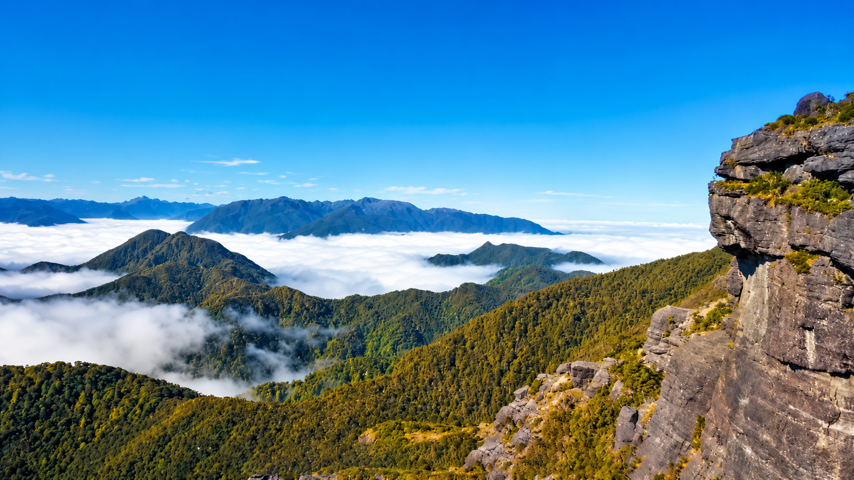 Towering mountains standing above a sea of clouds