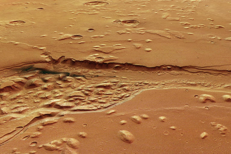 Strange, dark material spotted in an ancient channel on Mars, where ...