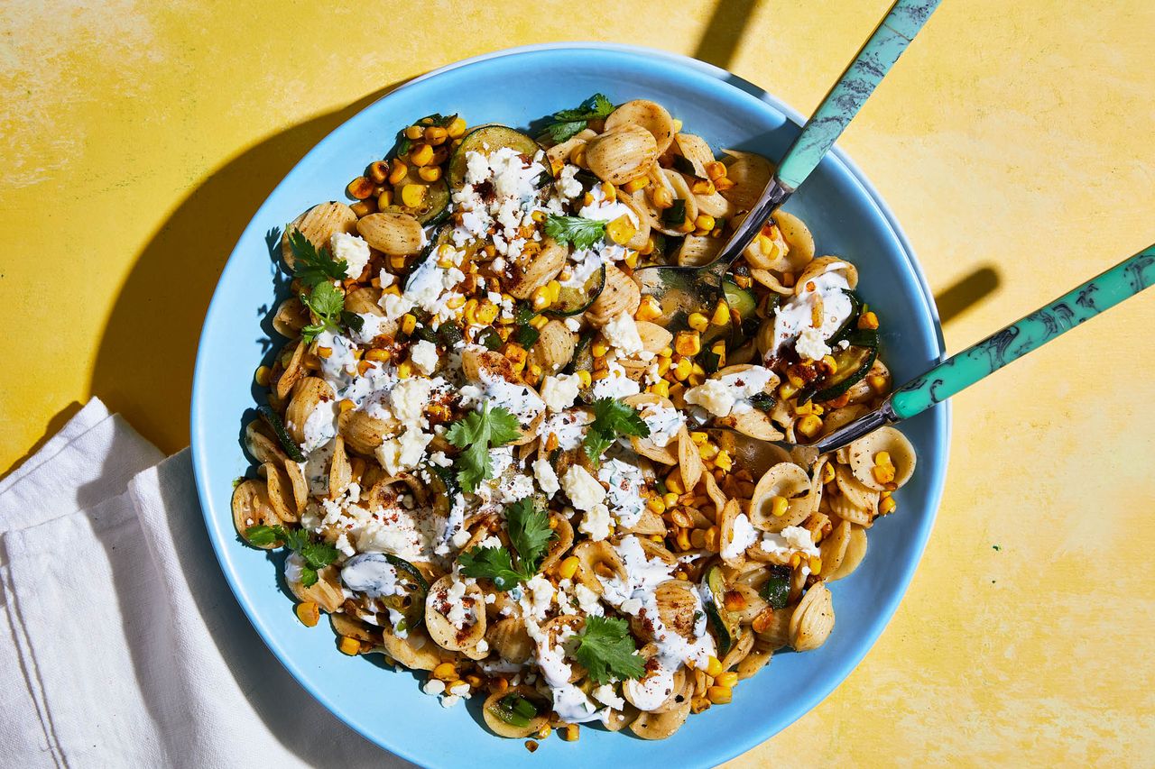 Overhead view of a light bluew serving bowl full of Esquites Pasta Salad