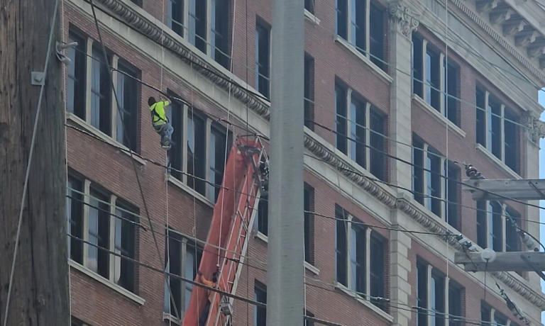 Window cleaners rescued from side of L&N building after platform ...