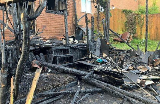 A view of the charred remains of the couples artificial lawn and garden fence