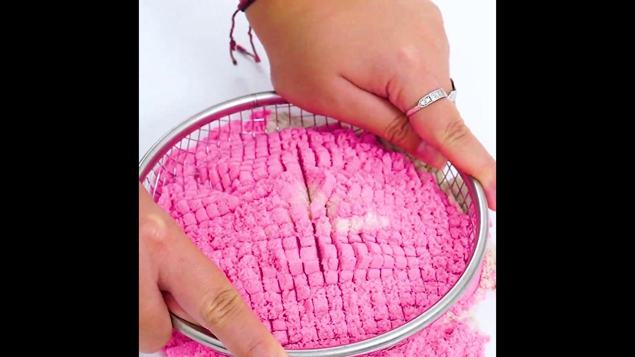 Satisfying cutting pink and white sand tower with knife revealing soft ...