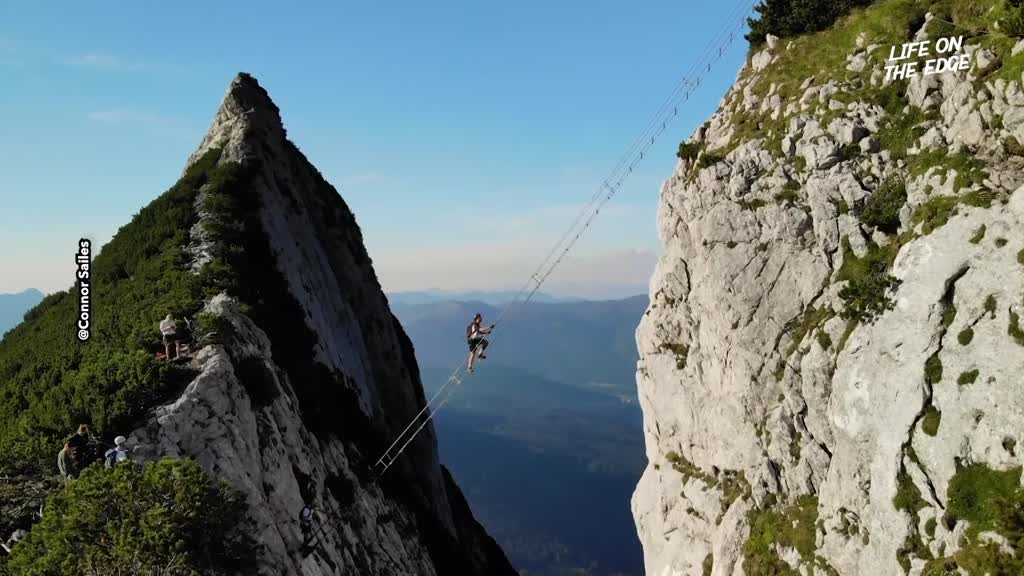 Thrill-seeker climbs ladder to heaven suspended between mountain peaks ...