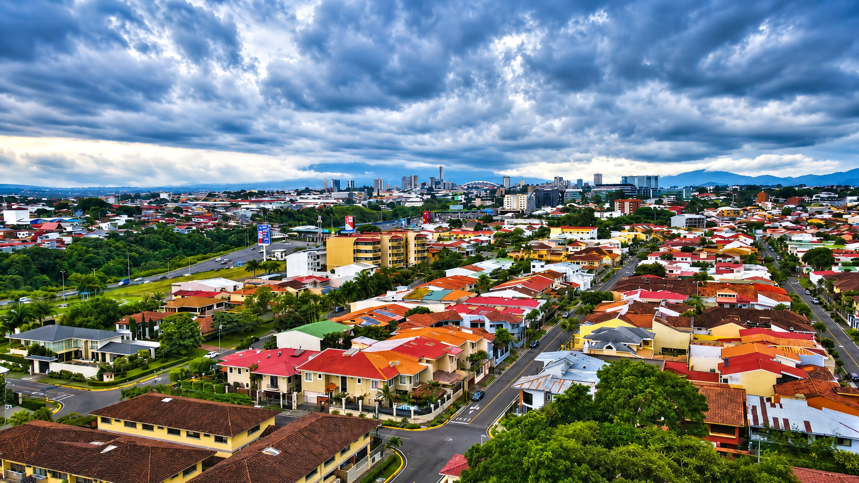Um horizonte urbano colorido sob nuvens de tempestade imensas