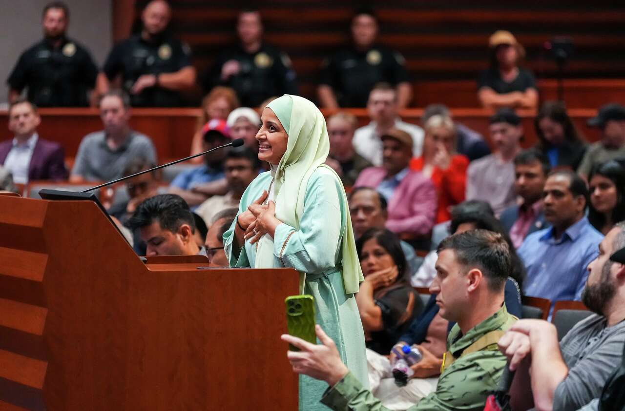 Frisco resident Aneela Charania speaks in favor of the proposed construction of a mosque and two temples while she is recorded by opponent Jake Lang (bottom) during a city council meeting in Frisco, Tuesday, May 19, 2026. (Smiley N. Pool/The Dallas Morning News)