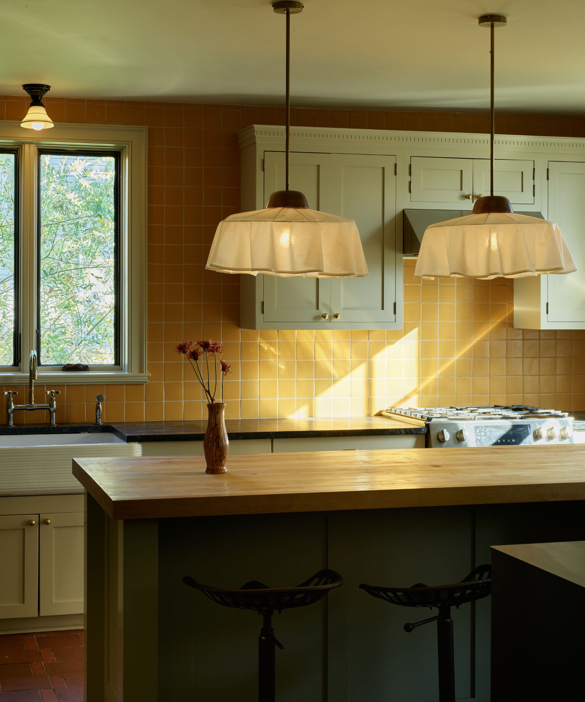 A cozy kitchen with light blue cabinets amd yellow backsplash tiles