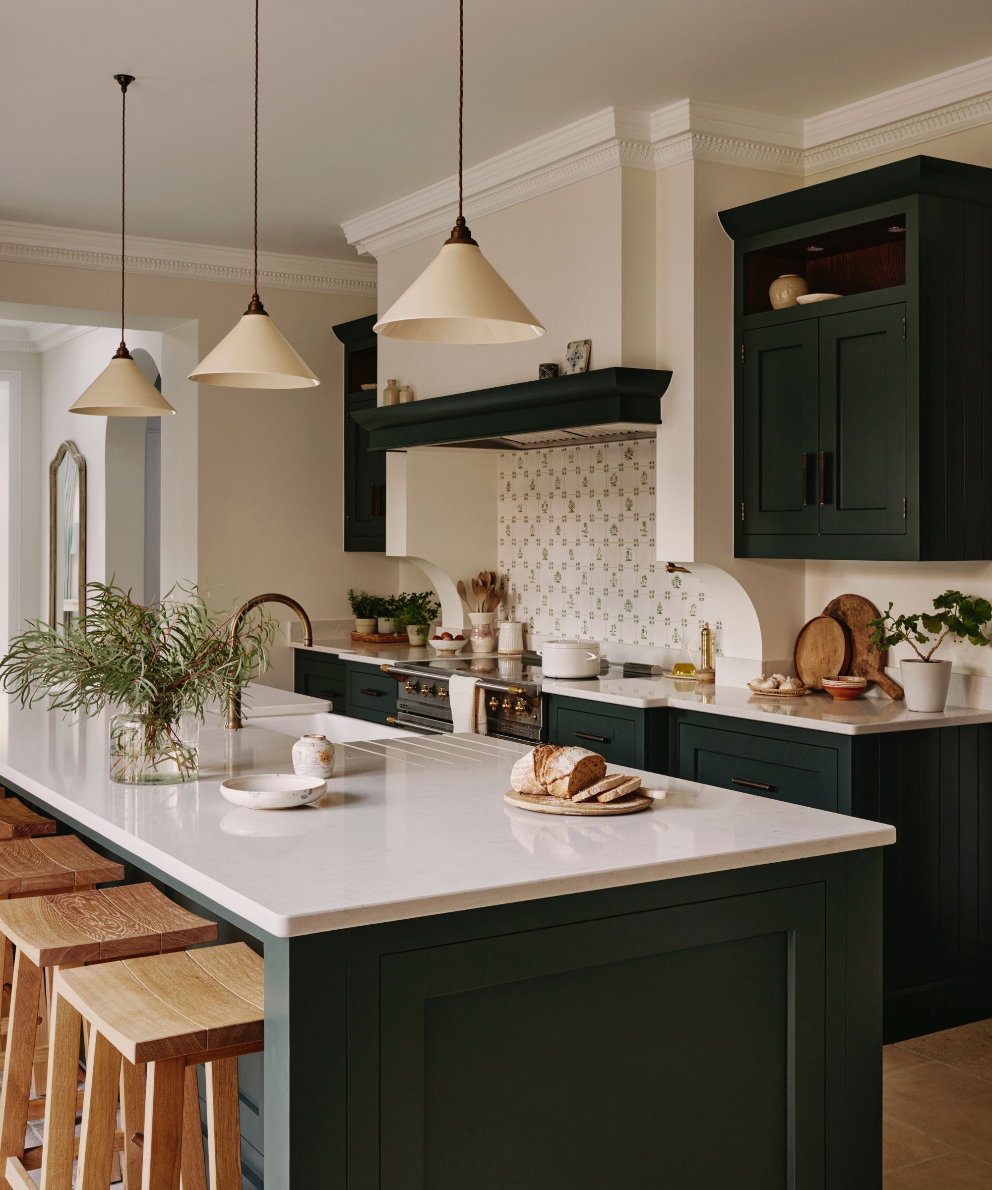 A country kitchen with dark blue cabinets, white countertops, and a backsplash made from delft tiles