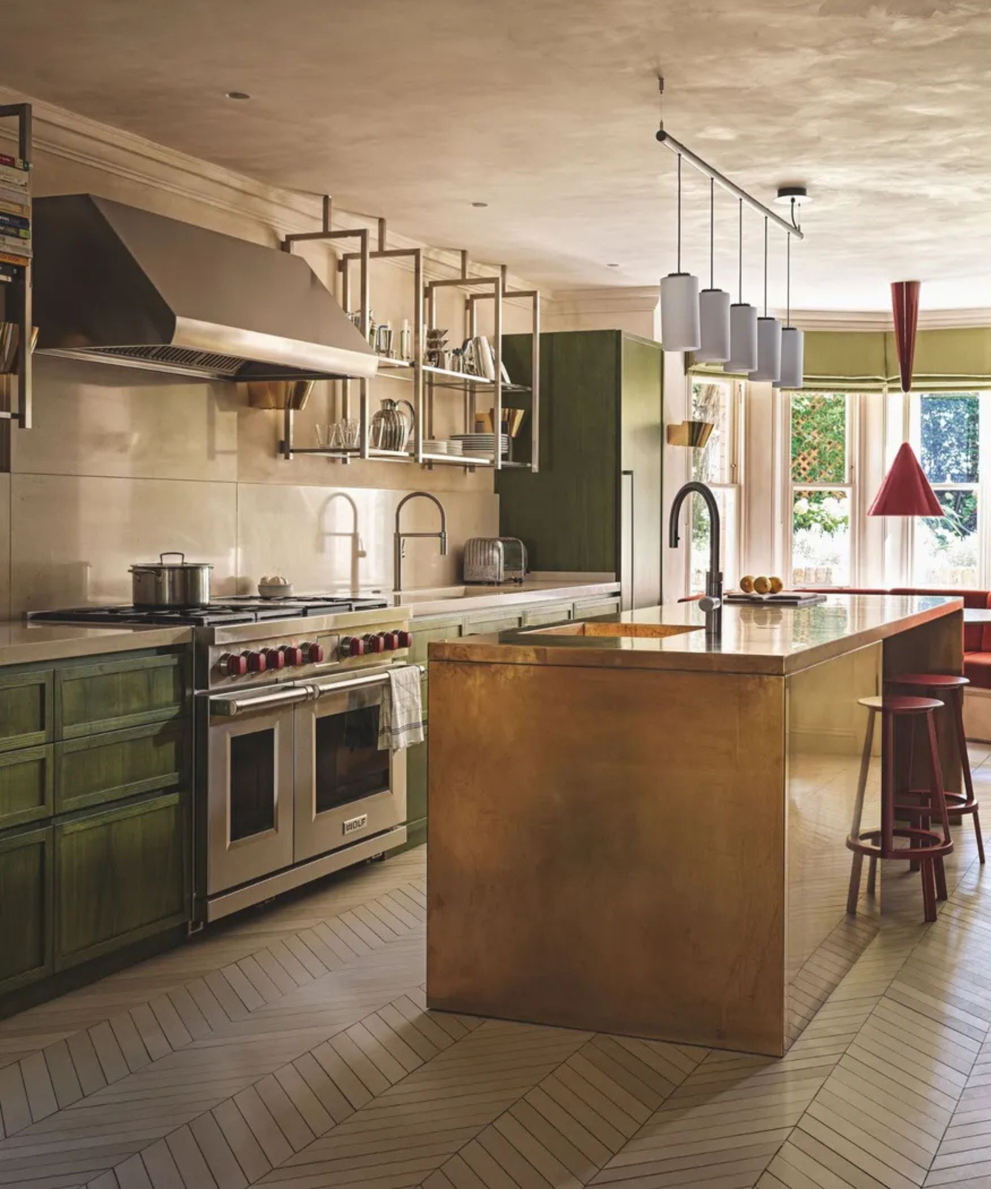 a rustic kitchen with a copper island, green cabinets, and a textured paint finish thourhgout