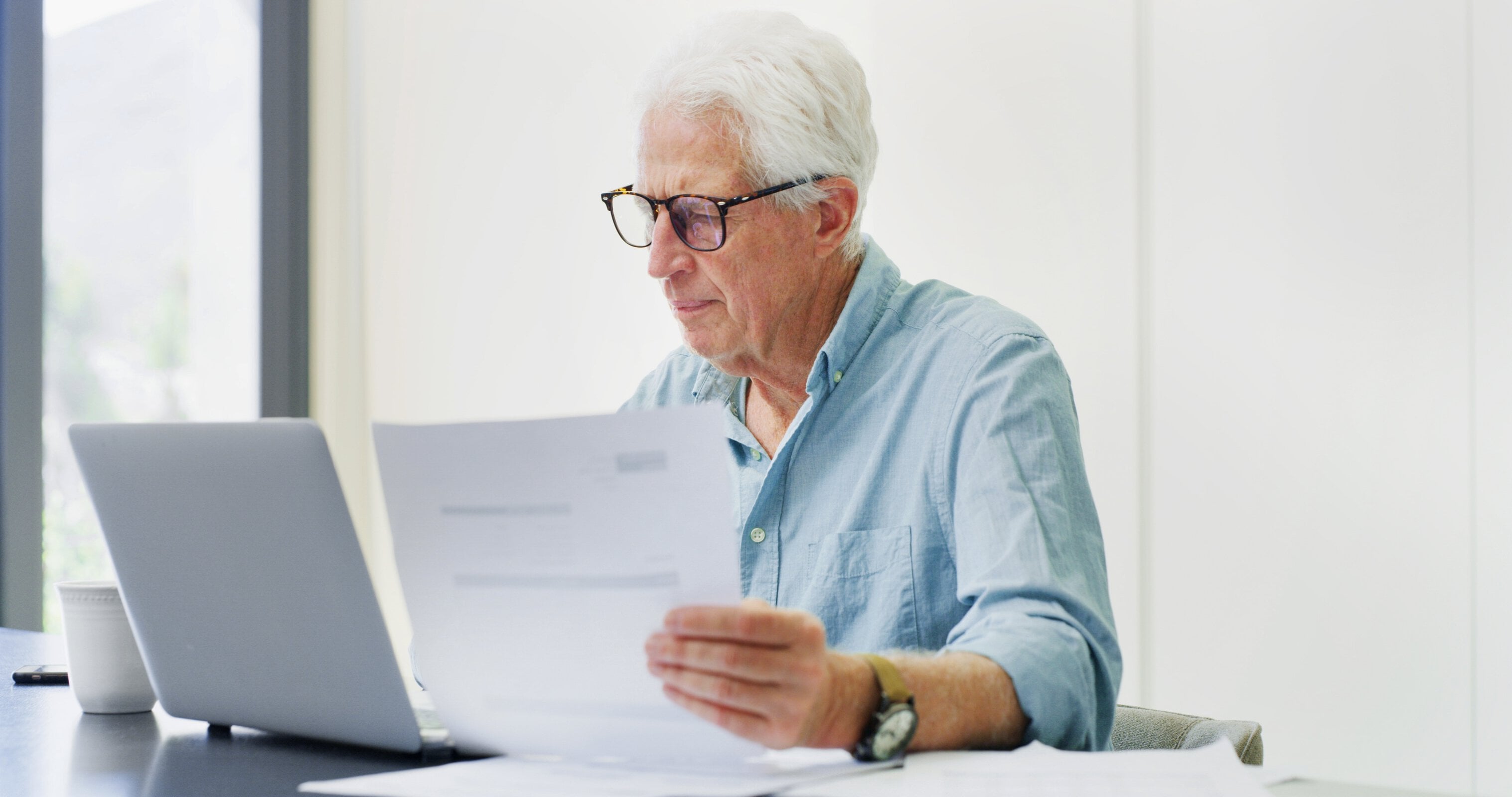 Documents, laptop and research with old man in home for retirement fund, asset management and credit score. Contact, online banking and pension account report with senior person in apartment