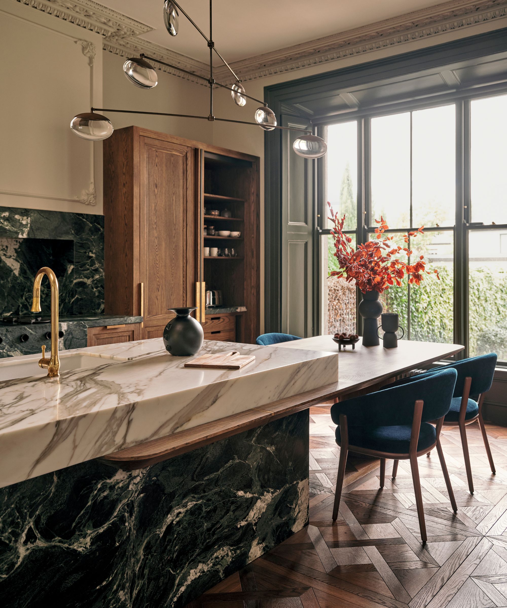 A chic kitchen with a staggered island to separate countertops and dining space