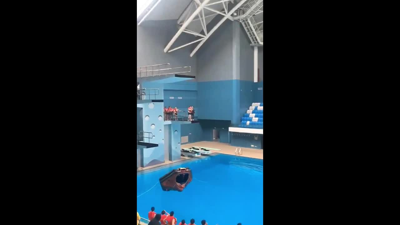 Man loses balance while jumping from diving platform into pool in ...