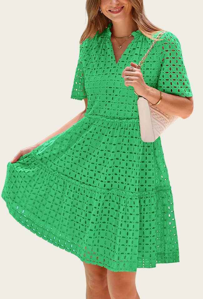 Person in a stylish, eyelet pattern dress holding a purse, posing for a fashion article on shopping