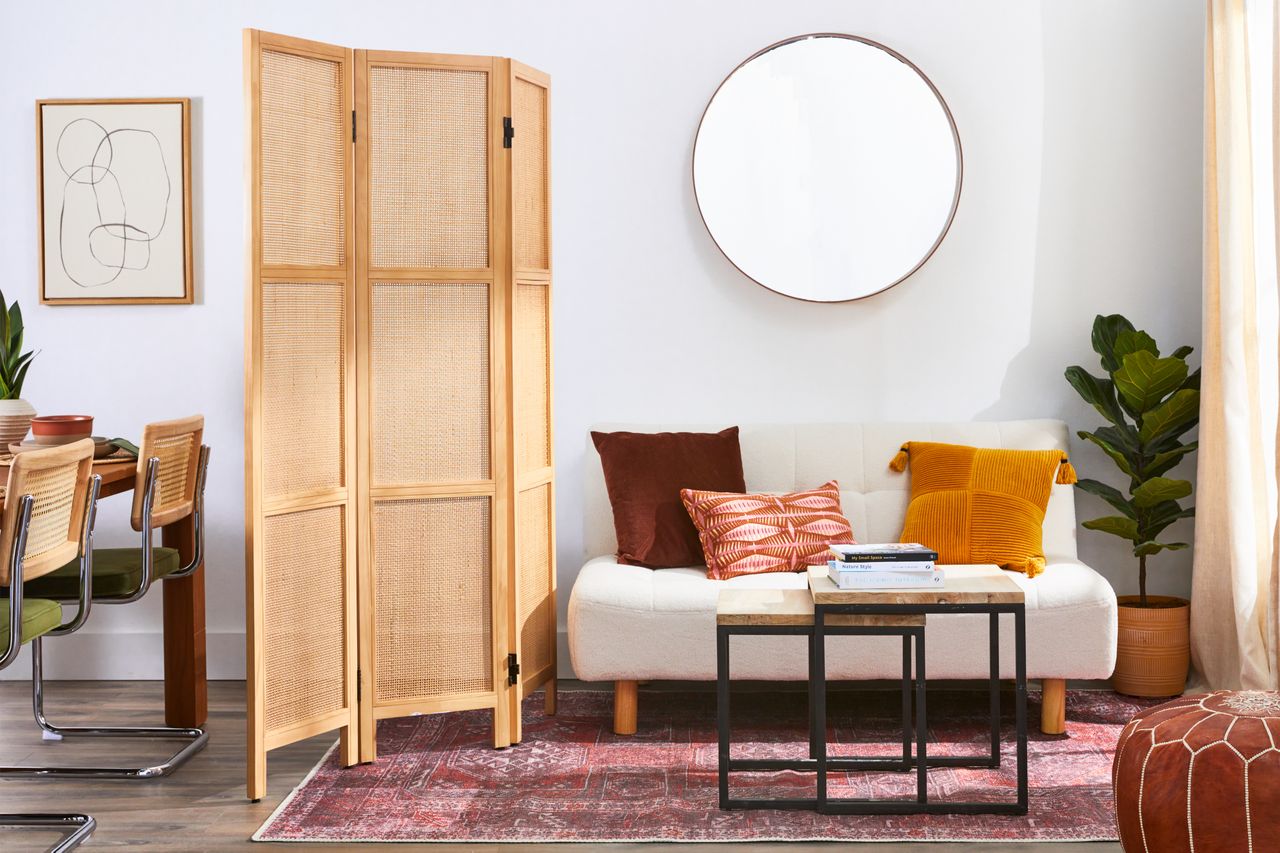 An accordion room divider separating a living room and a dining room