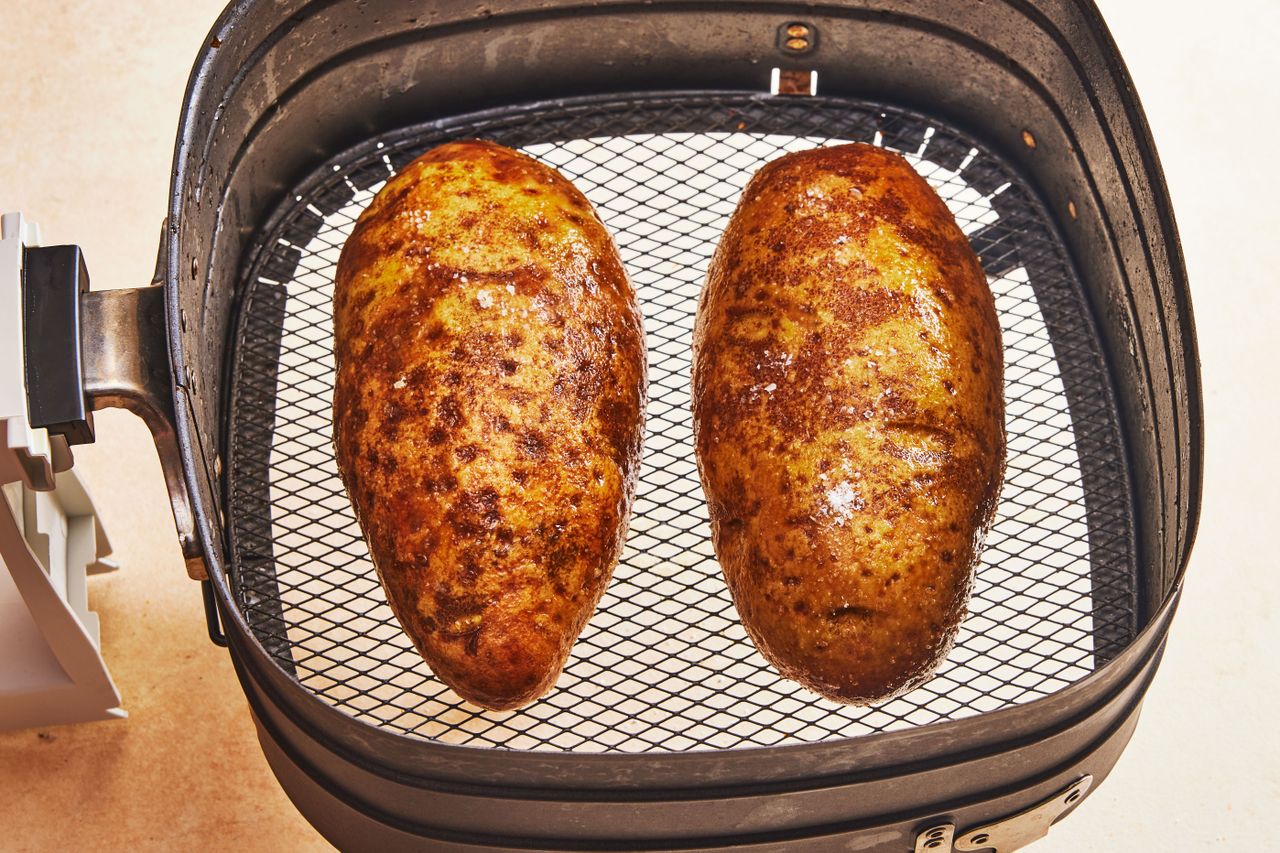 Southern Living Air Fryer Baked Potatoes putting the potatoes in the air fryer basket
