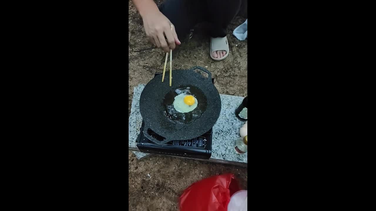Boy throws sand into fried rice while family cooks outdoors in Guangxi ...