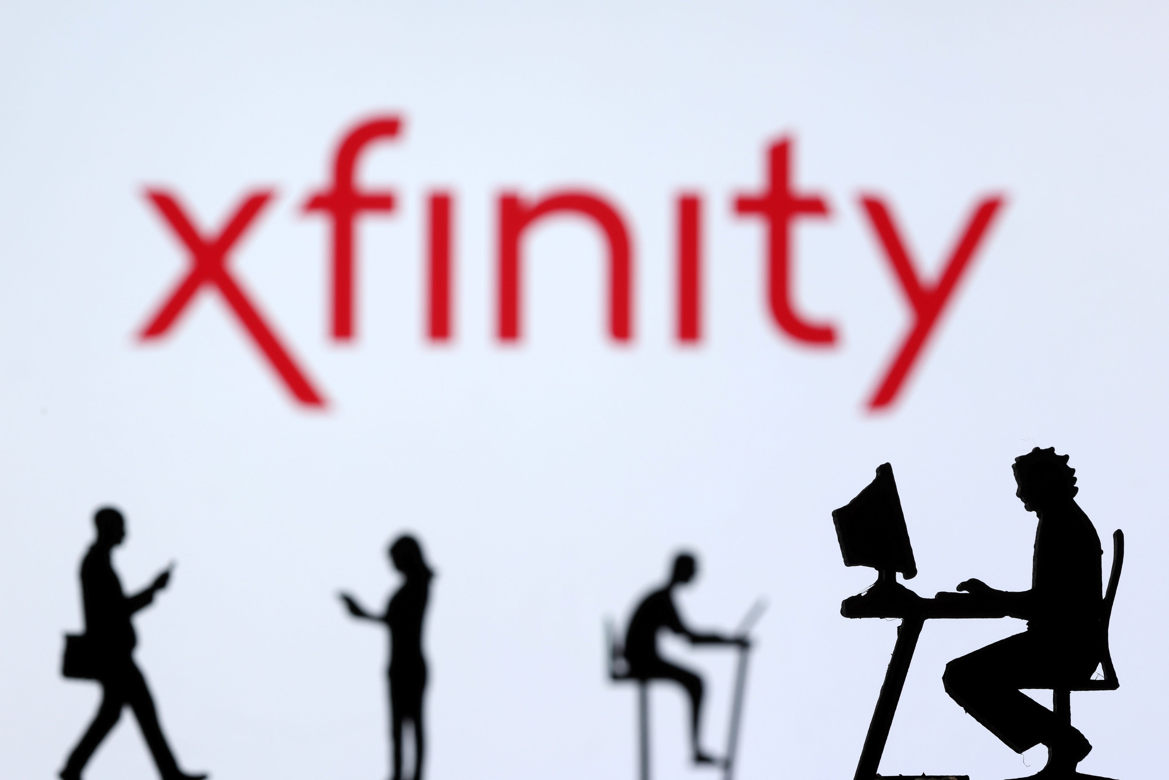 Small toy figures with laptops and smartphones are seen in front of displayed Xfinity Internet logo, in this illustration taken December 5, 2021. REUTERS/Dado Ruvic/Illustration