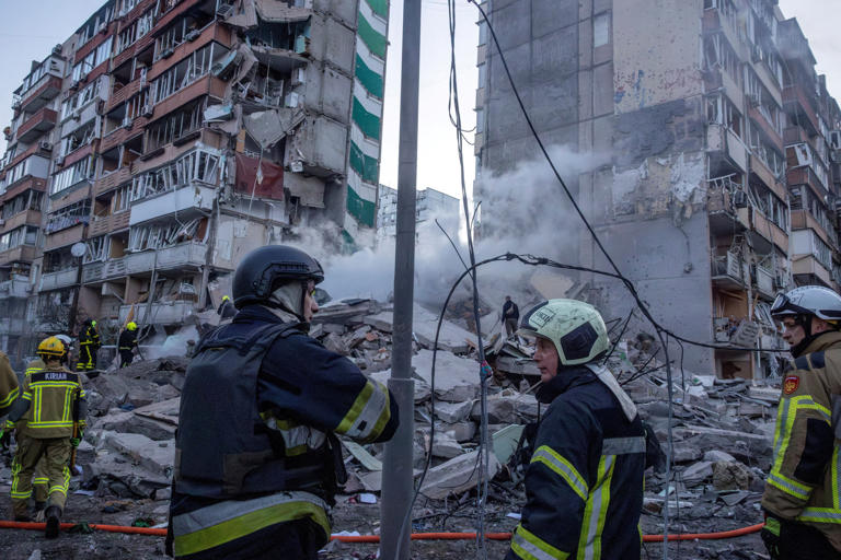 Damaged apartment buildings and rescue workers at the site of a Russian air strike in Ukraine.