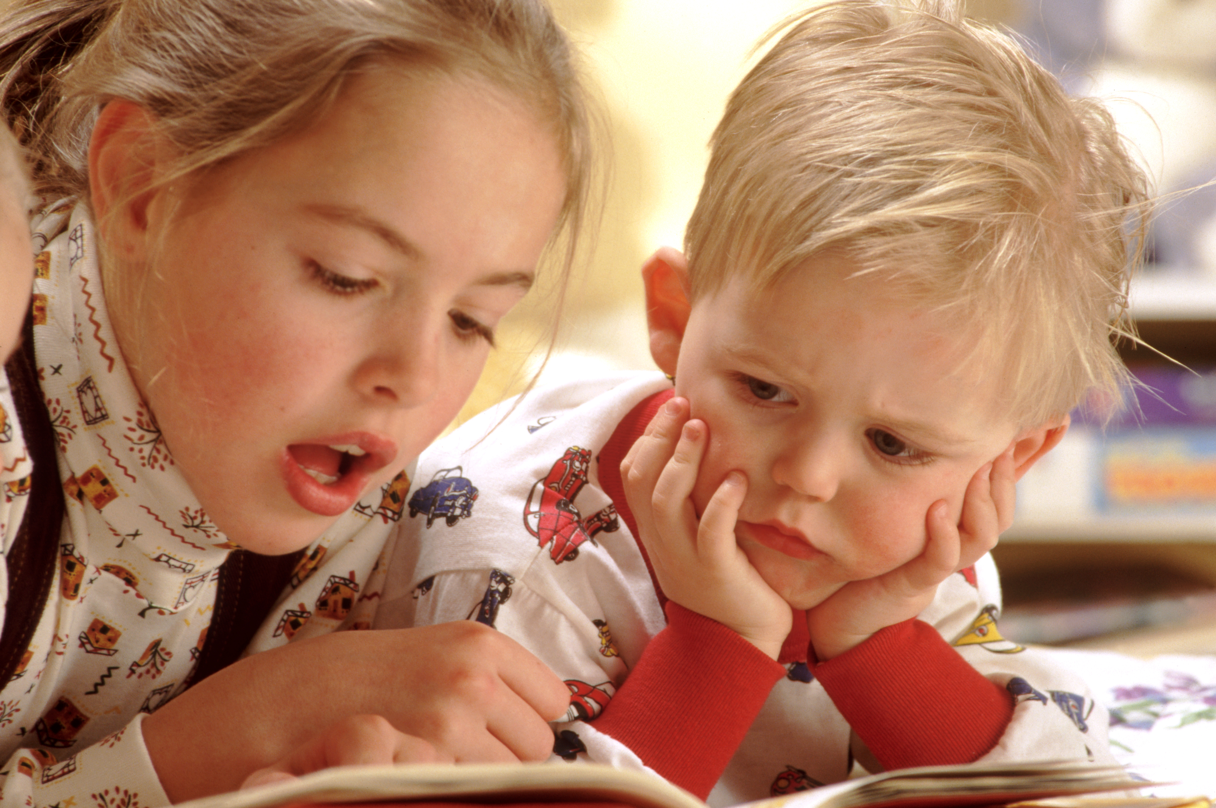 Girl reading to her brother
