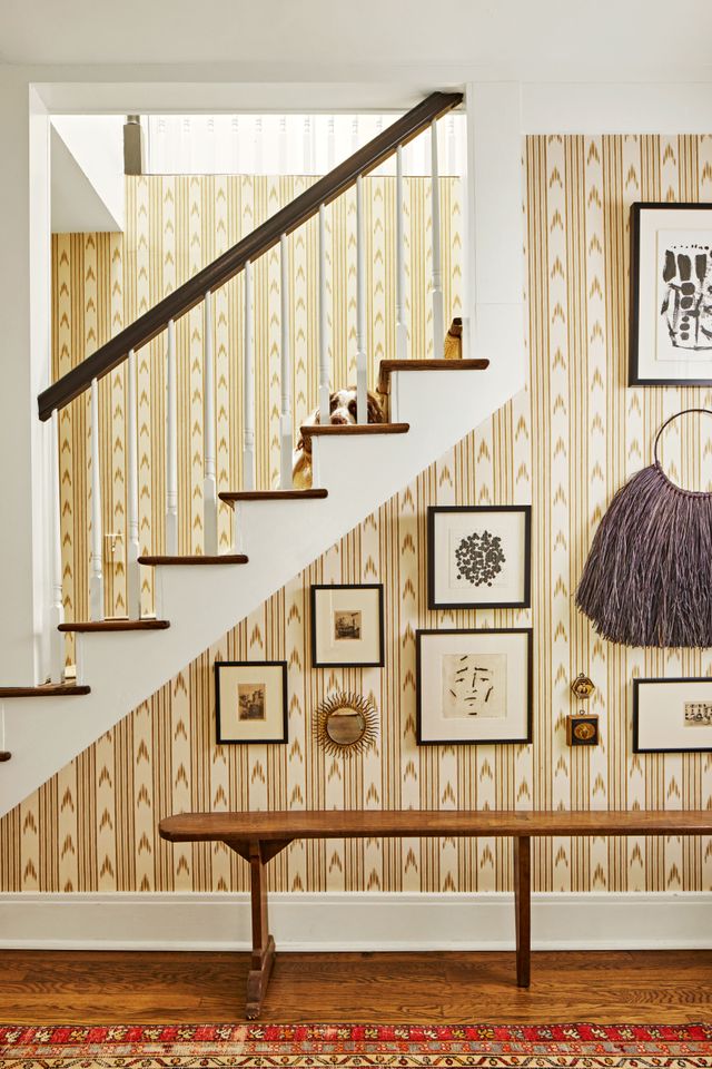 Entryway with bold wallpaper and bench with gallery wall