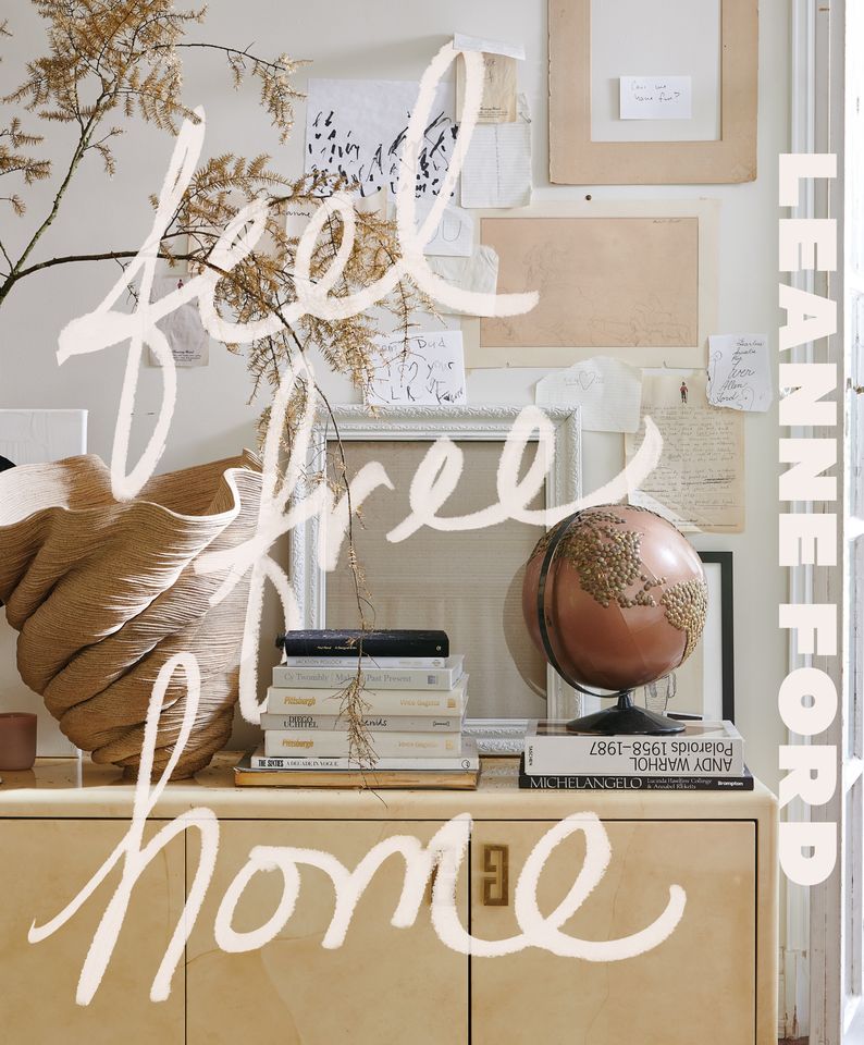 A styled interior arrangement including books a globe and soft decor elements with the words feel free home written over it