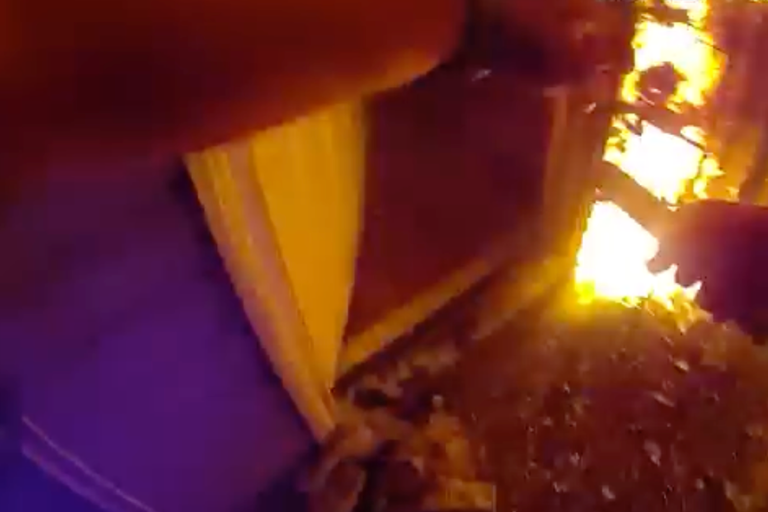 Police officer kicks down burning door to rescue mother and children