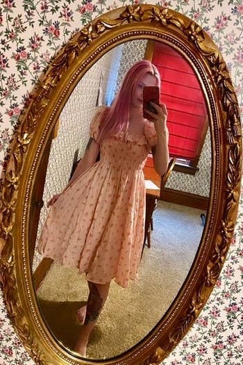 reviewer in the pink version with small flowers wearing the sleeves on the shoulder