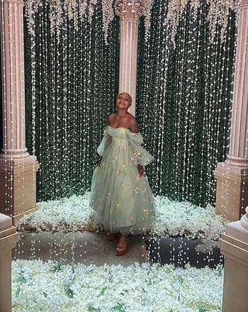 a reviewer in a long tulle dress with embroidered flowers on it