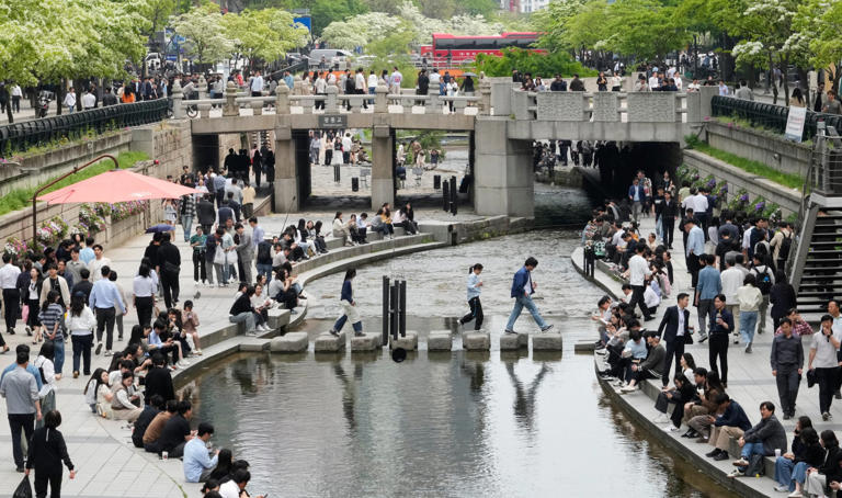 People walk by a stream in Cheonggye, Seoul, last month. Nearly half of South Korea's population have been exposed to AI tools. Photo: AP