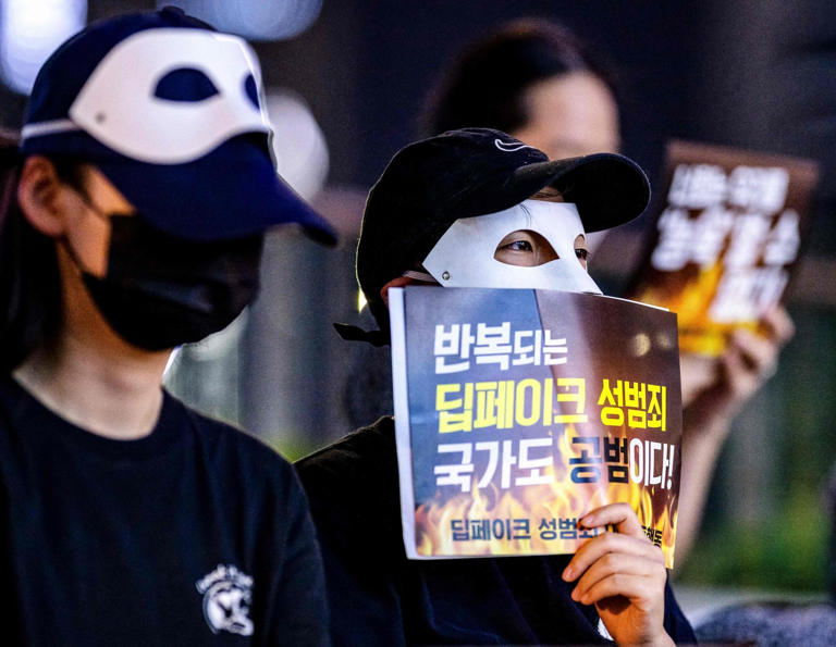 Mask-wearing activists protest again deepfake sex crimes in Seoul in 2024. Photo: AFP