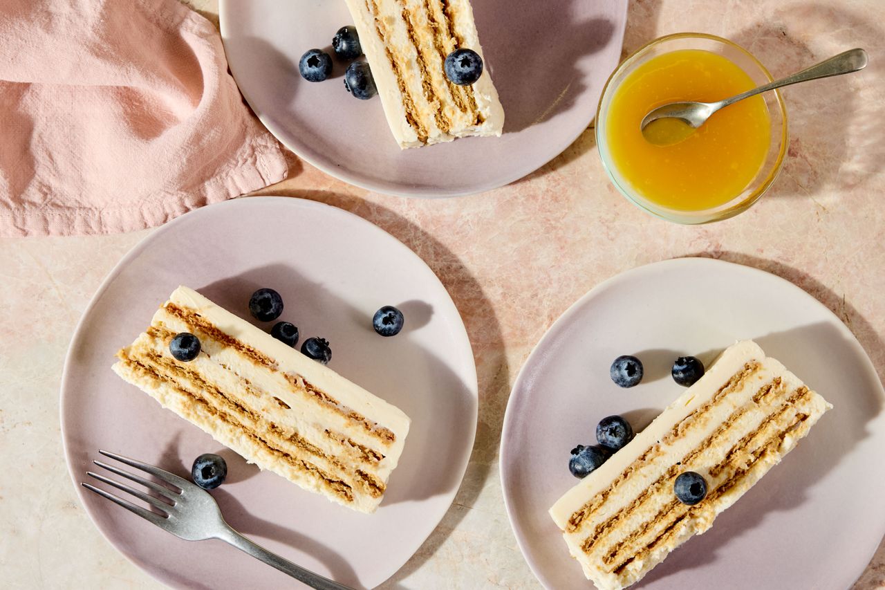 Slices of lemony layered cheesecake on light pink plates.