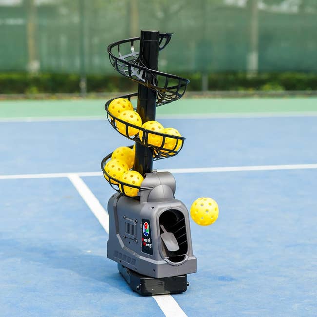 Tennis ball machine on a court launching yellow balls, showcasing an automatic practice tool ideal for players looking to improve their game