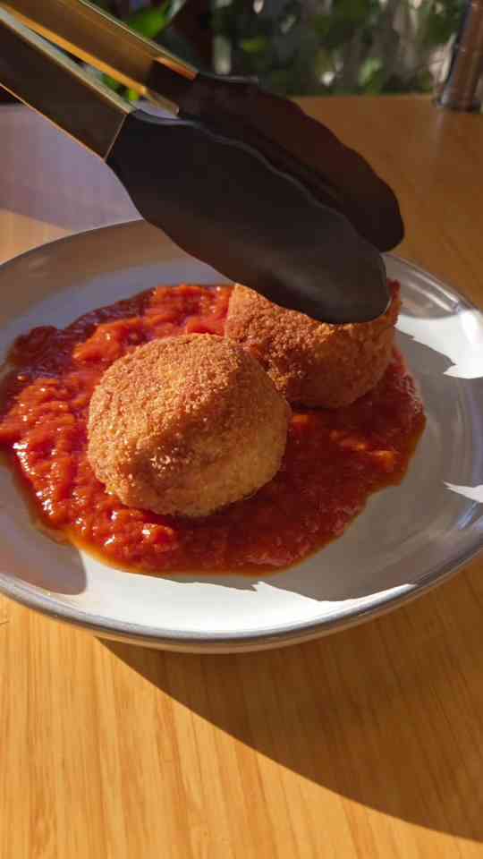 Golden arancini with melty cheese and basil oil