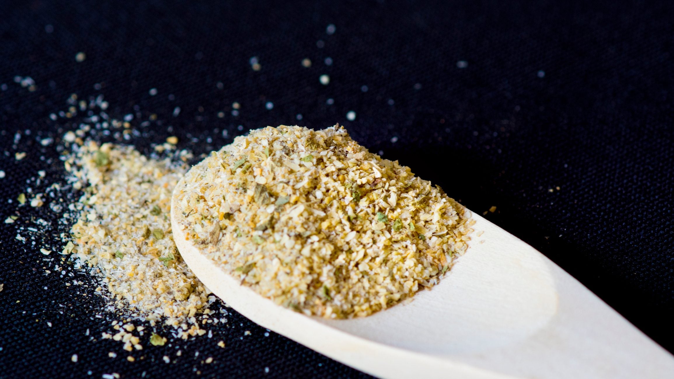 Mixed Spices In Wooden Spoon On Black Background.