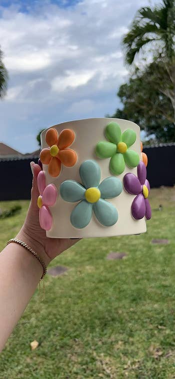 reviewer holding a planter with a flower design