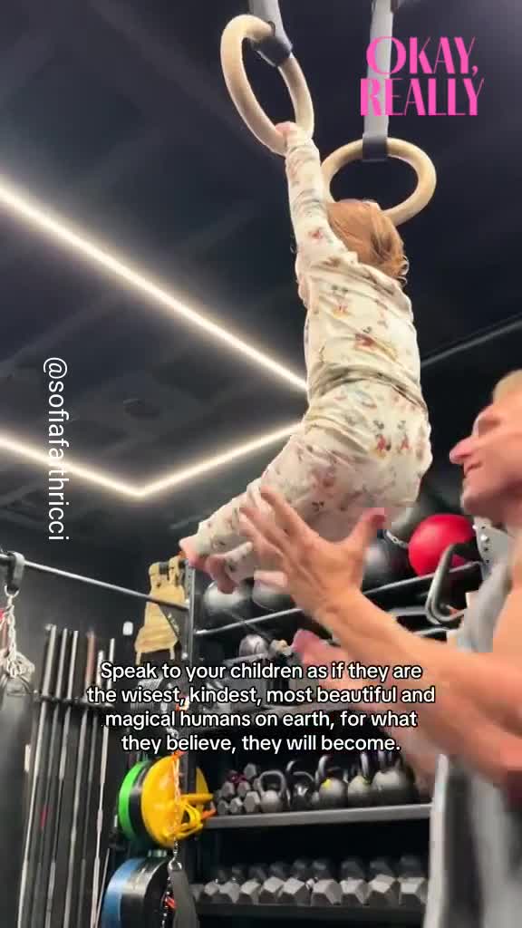 Buff baby holds herself on gym rings