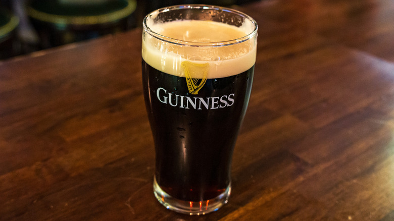 A pint of Guinness sitting on a pub table.