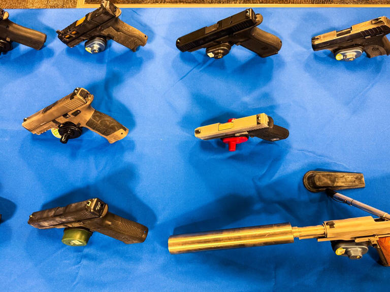 Police seize 21 loaded handguns, drugs, and cash from apartment
