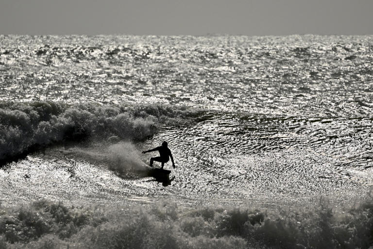 Un surfista surca una ola en condiciones adversas en la bahía de Manu (AFP/Getty)
