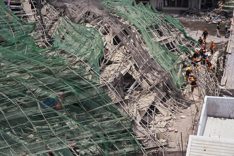 Rescue workers search for the remains of the victims amid the debris of the nine-storey building under construction that collapsed in Balibago, Angeles City, Pampanga, Philippines, May 26, 2026. REUTERS/Noel Celis